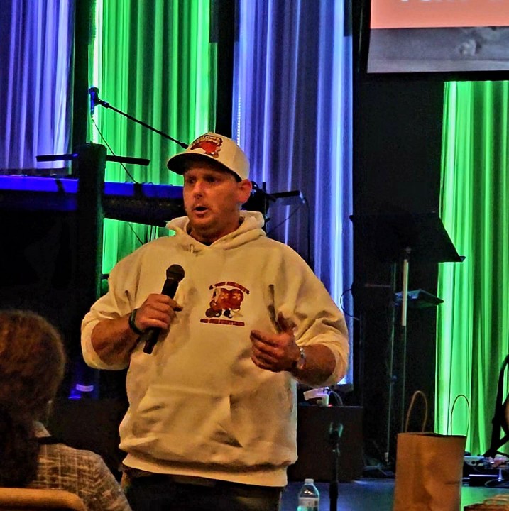 Keith speaking on stage, sharing his testimony