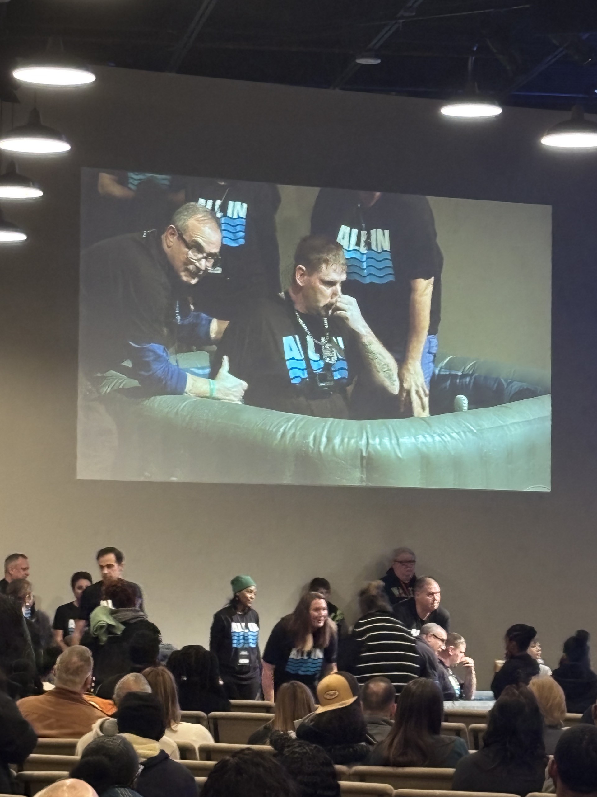 Keith being baptized at his recovery church, projected on the auditorium screen