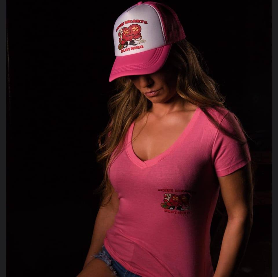 NVUS Hearts customer holding God Over Everything shirt at venue